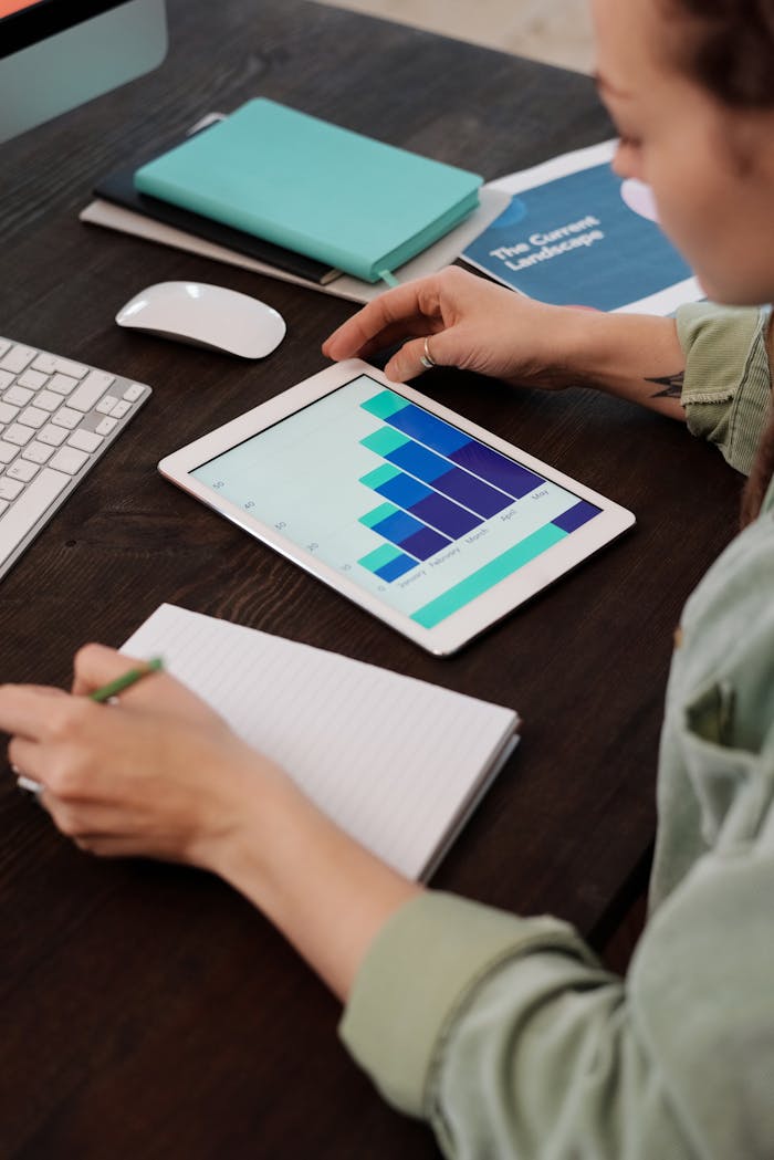 hero-img Focused person working on digital tablet analyzing business graphs at desk.